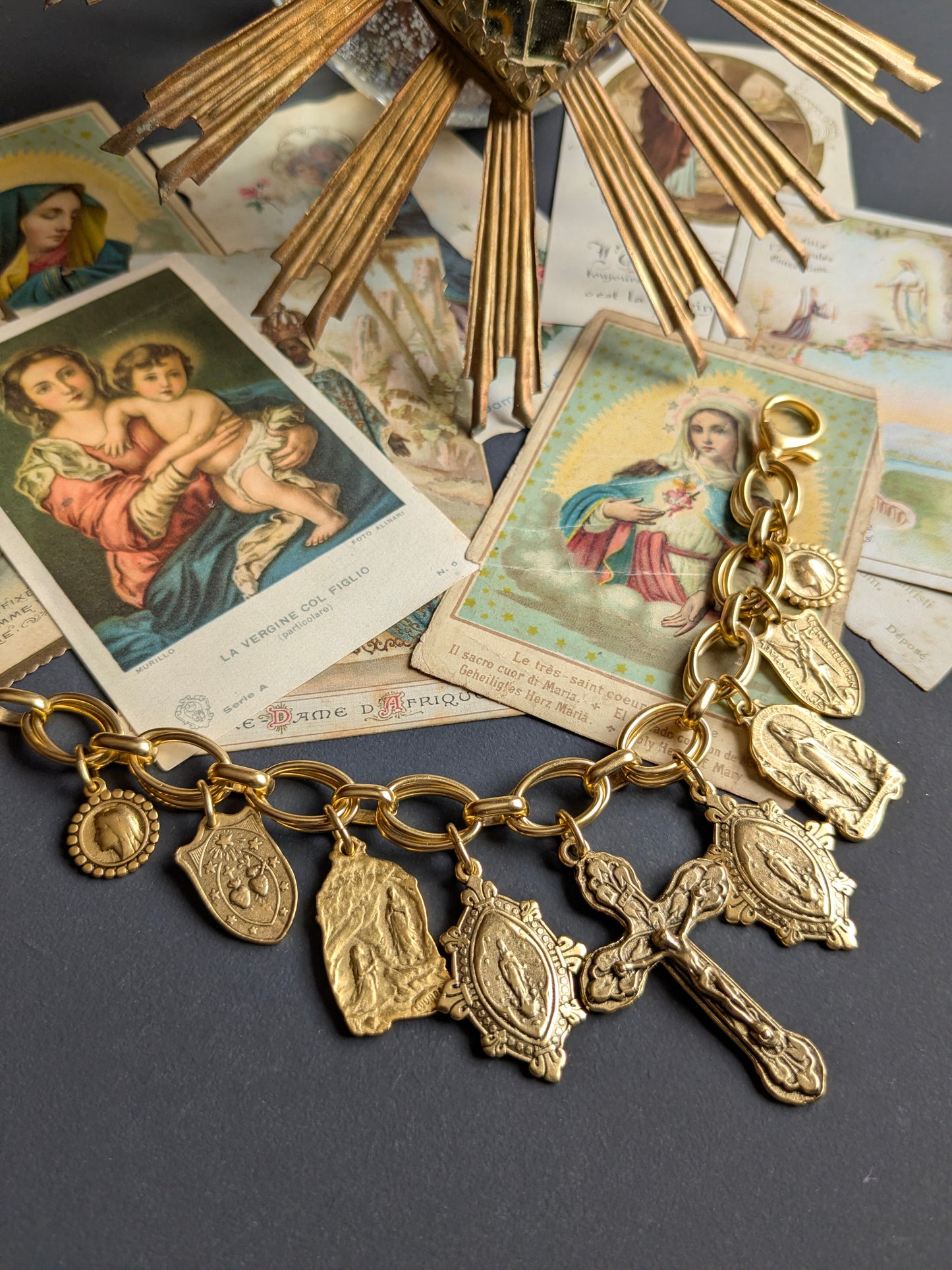 Bracelet Rédemption par Mudra, crucifix central entouré de médailles réversibles Notre-Dame de Lourdes en laiton doré 12kt.