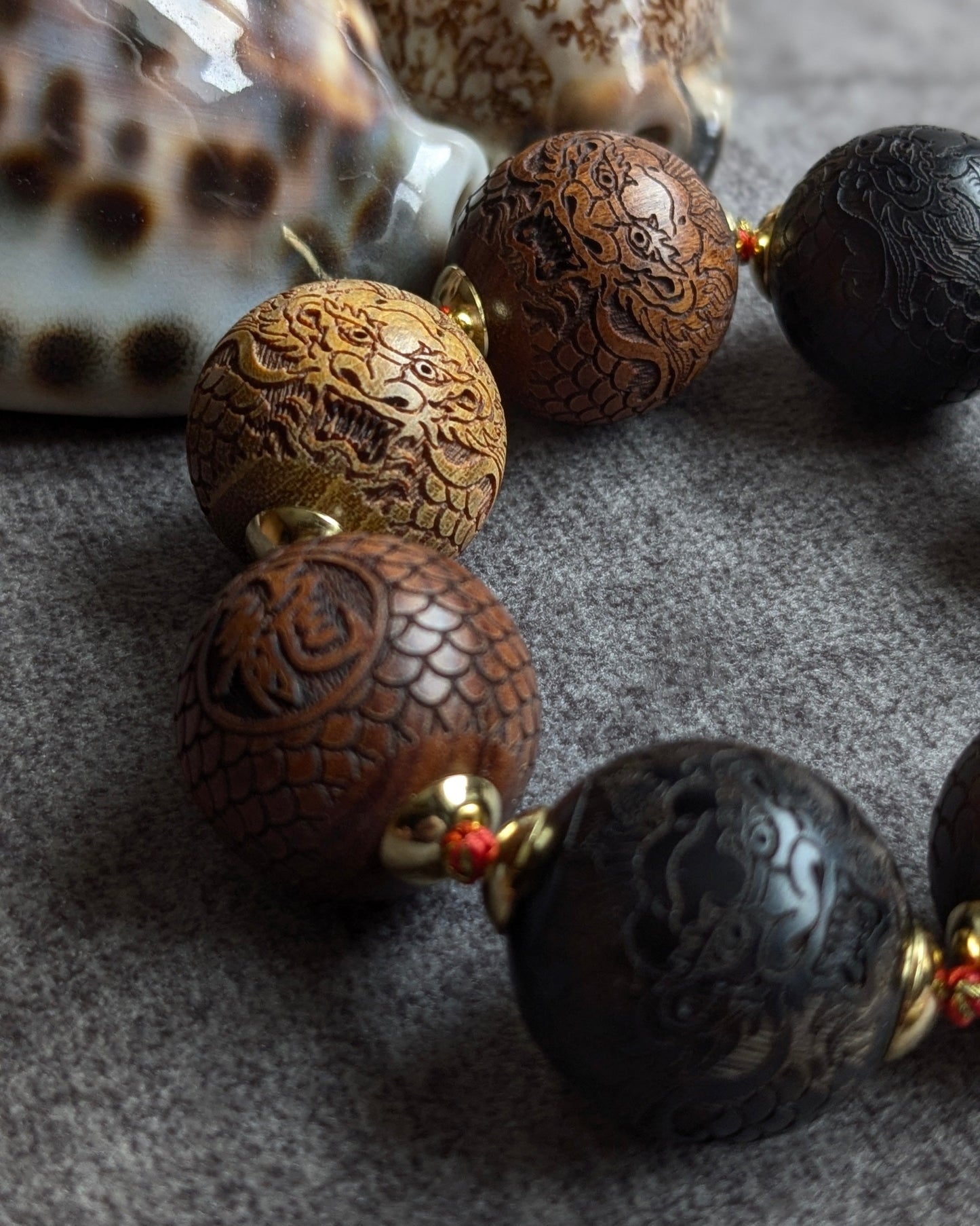 Détail perle dragon bois sculpté 20mm aux nuances miel et chocolat sur bracelet artisanal