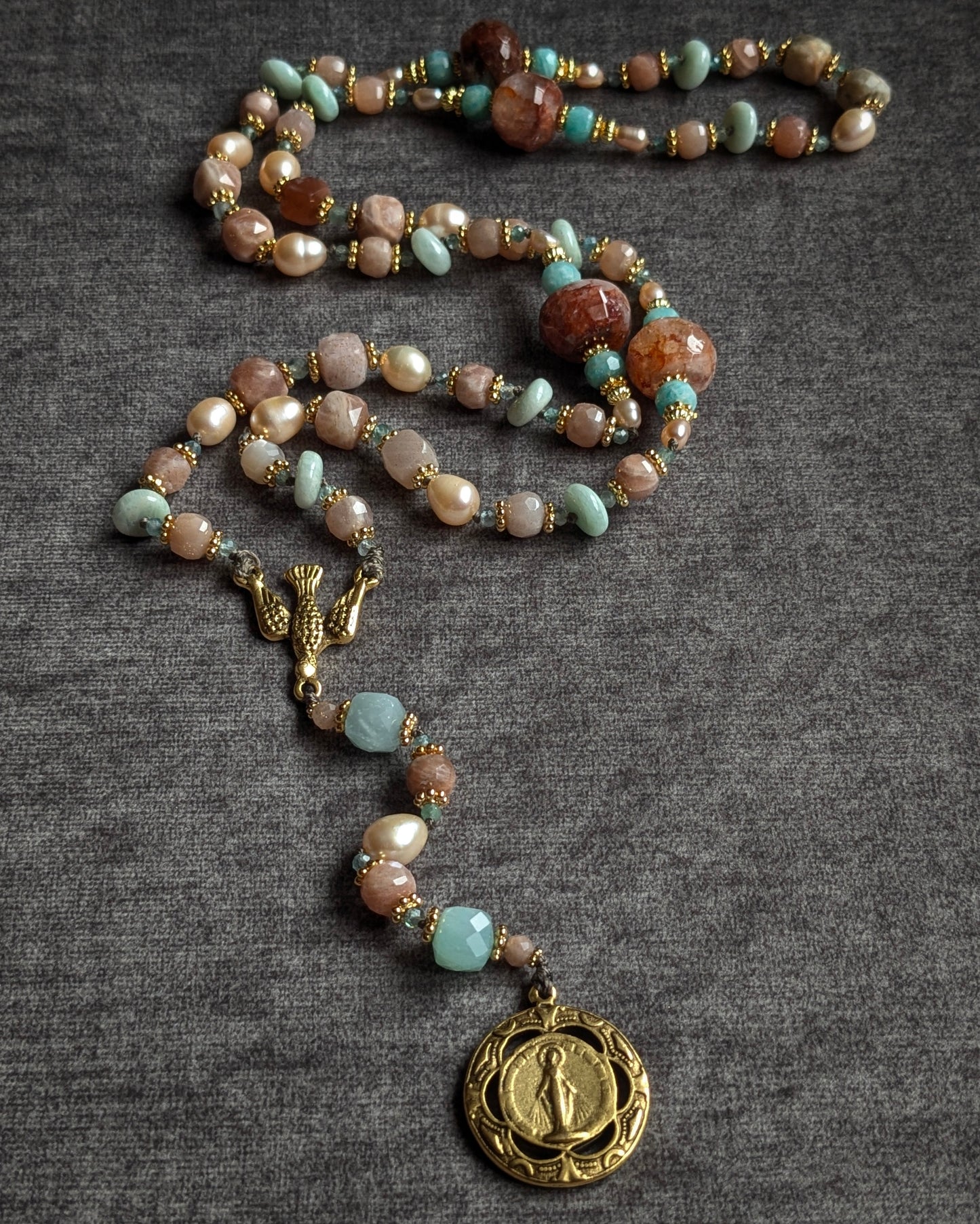 Détail des grains noués à la main : perles d'eau douce satinées, quartz hématoïde rutilant et cornaline claire sur fil coloré