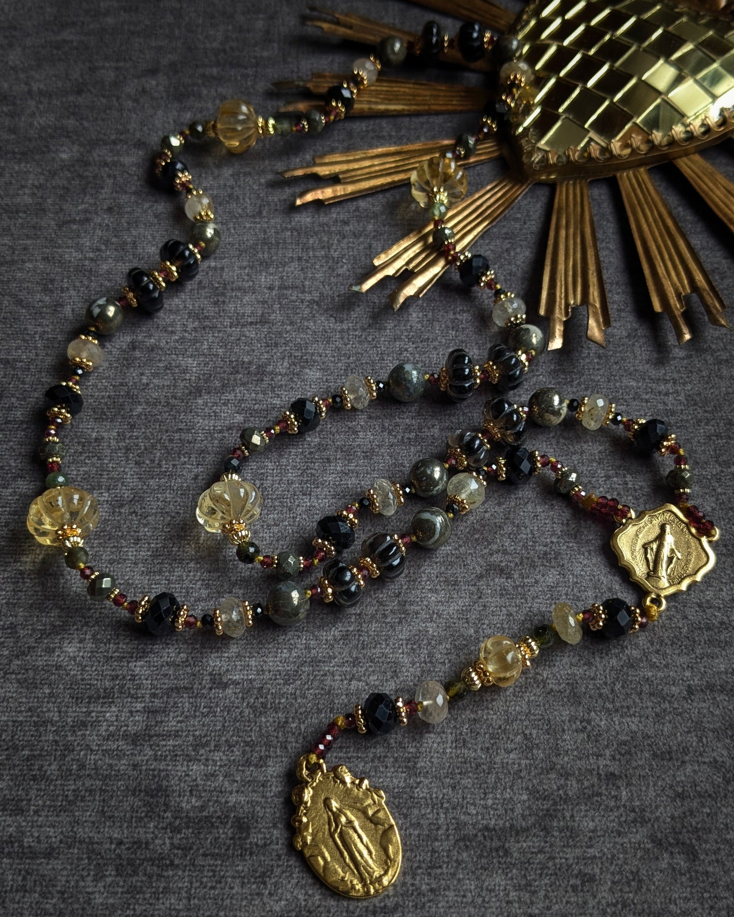 Long chapelet artisanal aux contrastes de matières entre l'onyx facetté brillant et la tourmaline noire mate.