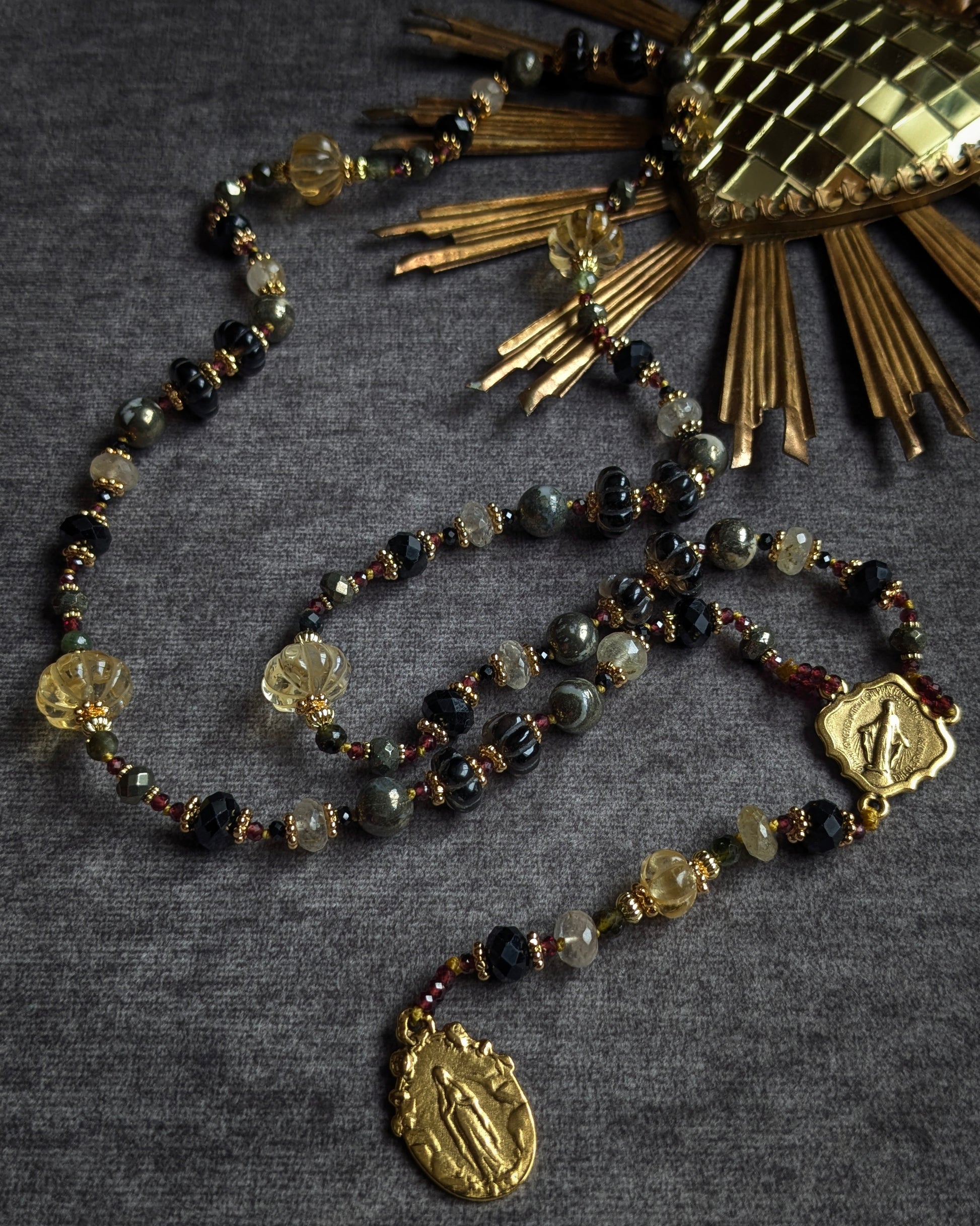 Long chapelet artisanal aux contrastes de matières entre l'onyx facetté brillant et la tourmaline noire mate.