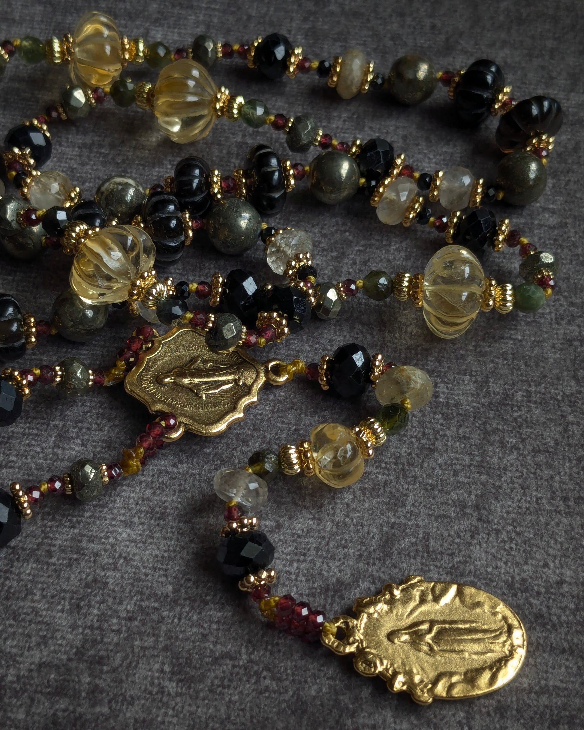 Bijou de dévotion de 70 cm mêlant pierres d'ancrage noires et éclats dorés de quartz à rutiles et citrine.