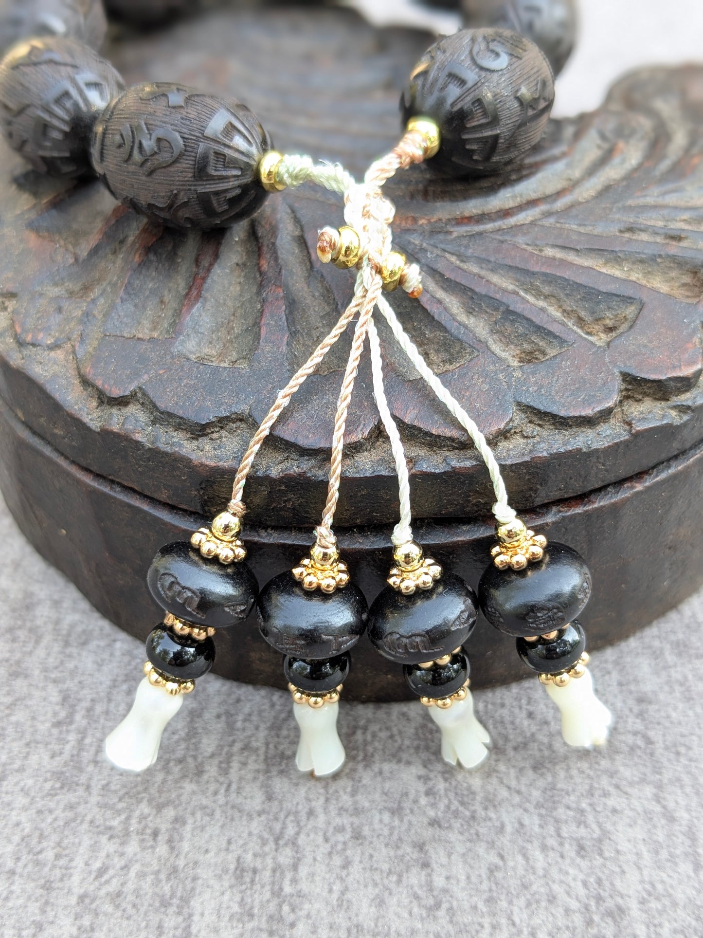 Détail des pampilles du bracelet Chenrezi Mudra en santal, onyx et nacre