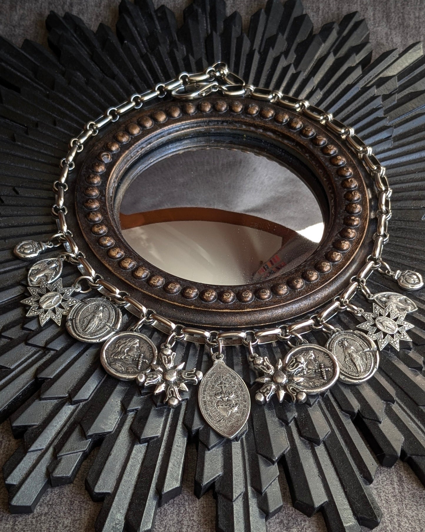 Collier Manifesto de la collection Oh My God par Mudra, une parure ex-voto argentée composée de 11 médailles religieuses en étain antique sur maille architecturale.