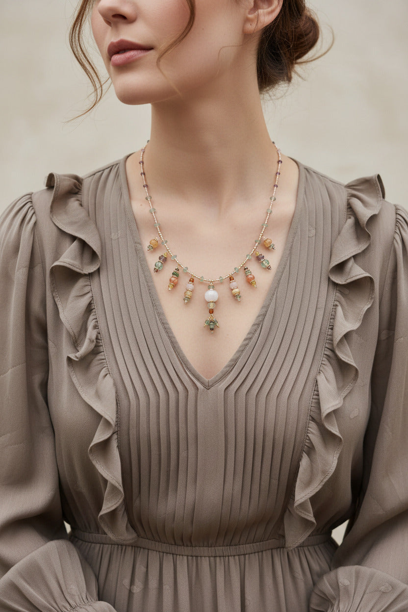 Le collier Harivya porté, révélant sa ligne souple et ses nuances de roses pâles et verts clairs.