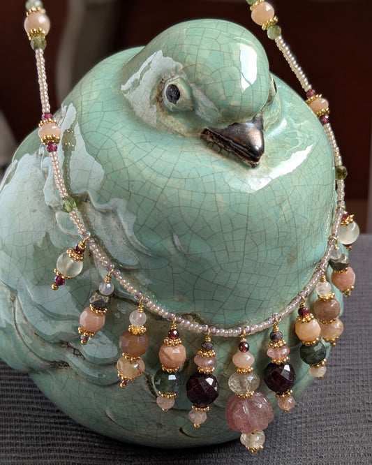 Zoom sur les éclats lumineux du quartz rutile doré et du quartz fraise translucide composant le collier Navisha.