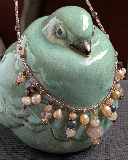 Collier Oryana 47 cm en rocailles japonaises avec breloques en quartz fraise sculpté, perles d’eau douce, pierre de lune pêche, agate indienne verte, agate sakura, grenat, tourmaline verte et quartz rutile doré, bijou artisanal bohème chic et précieux.