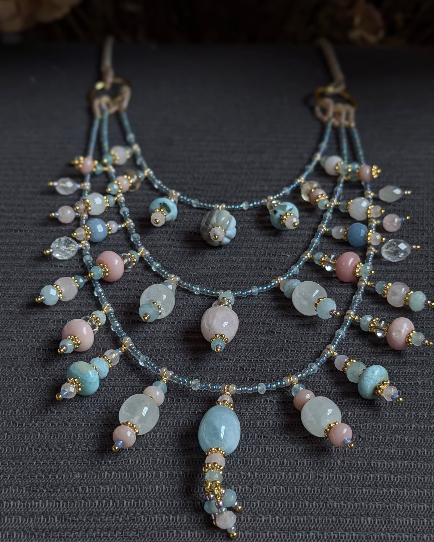 Zoom sur les breloques en opale boulder et le travail de rocailles Miyuki du collier triple Pravisha.