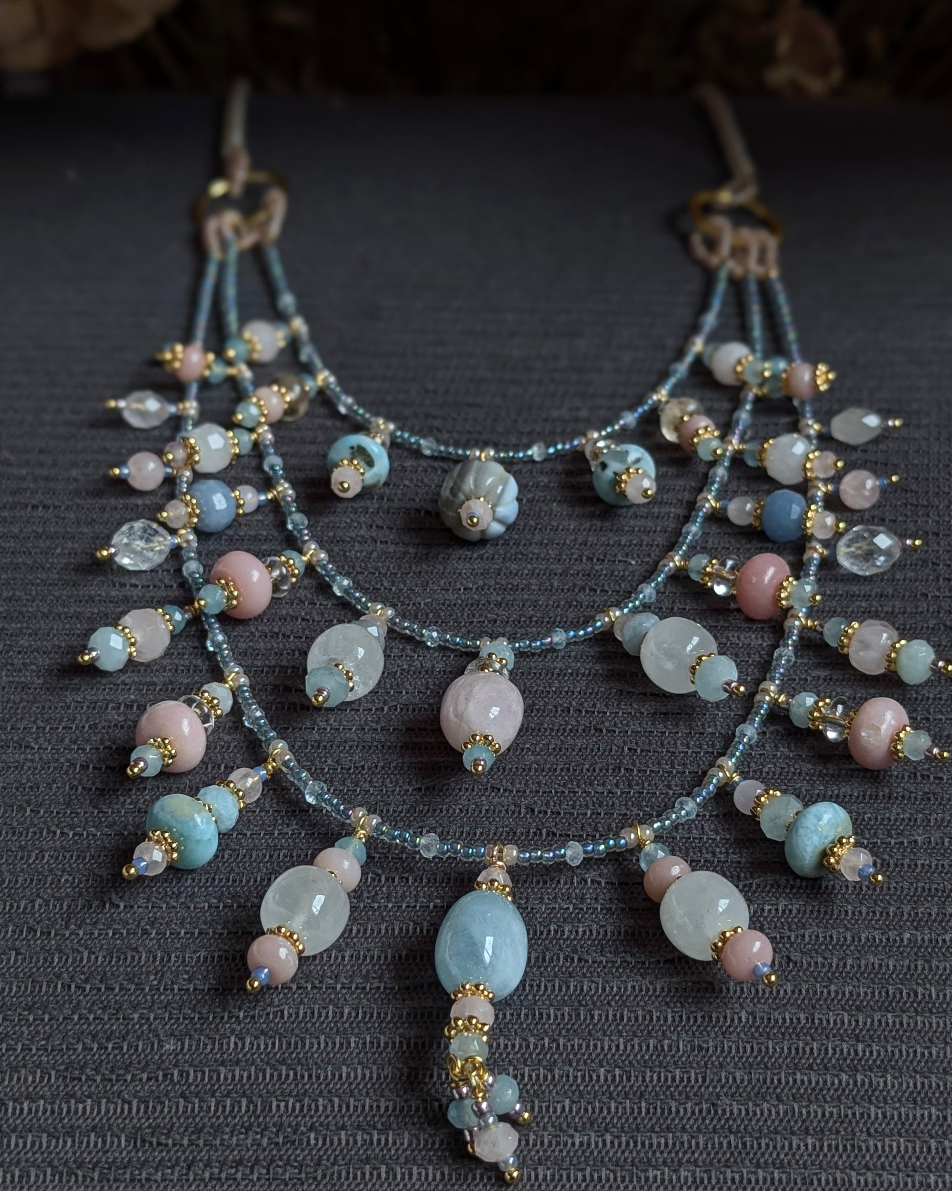 Zoom sur les breloques en opale boulder et le travail de rocailles Miyuki du collier triple Pravisha.