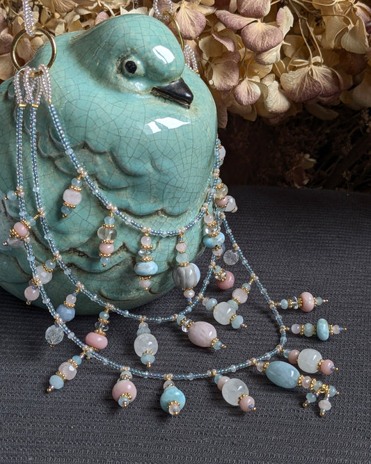 Collier trois rangs Pravisha aux nuances Pantone printemps-été 2026, parsemé de breloques en pierres fines : opale boulder, quartz rose, aigue-marine, opale rose, aventurine bleue, beryl bleu, cristal de roche et rocailles Miyuki, élégant et lumineux.