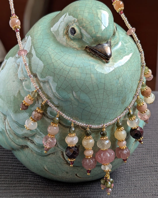 Ras de cou Kaivani 45 cm en rocailles japonaises avec breloques en quartz fraise sculpté, quartz rutile doré, agate sakura, tourmaline verte, pierre de lune pêche et grenat, bijou bohème chic artisanal.
