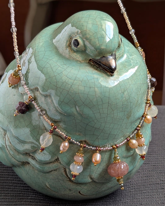 Collier Jivika 50 cm : quartz fraise sculpté, perles d’eau douce, agate sakura, grenat et tourmaline verte. Pièce unique artisanale bohème chic.