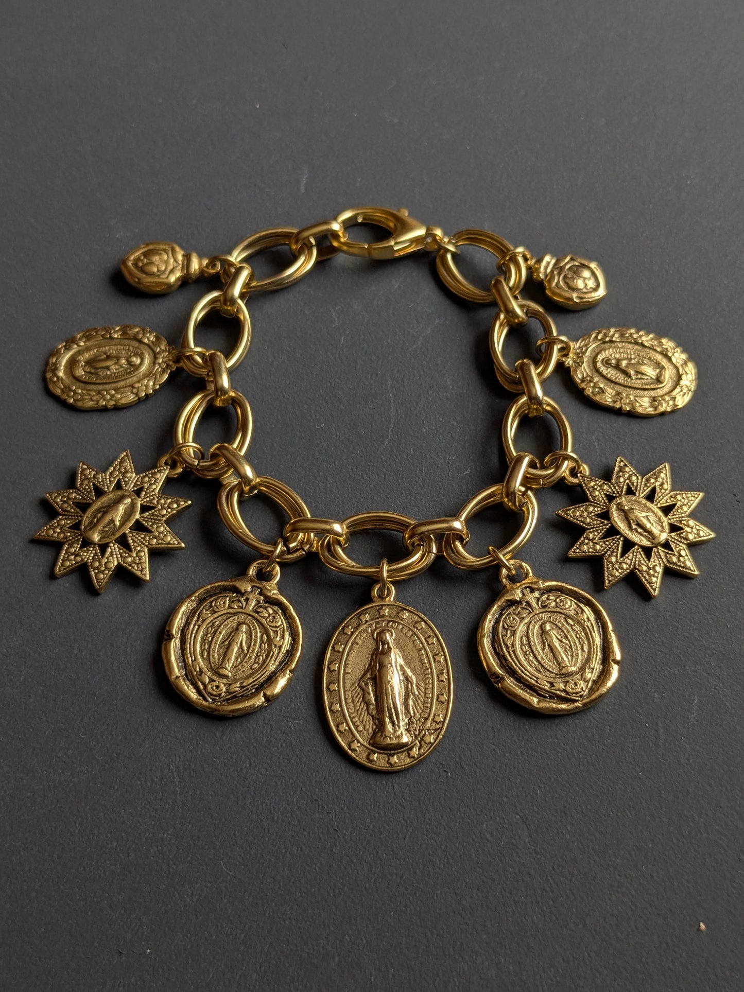 Détail des sept silhouettes de la Médaille Miraculeuse sur le bracelet Constellation, laiton plaqué or 12kt.