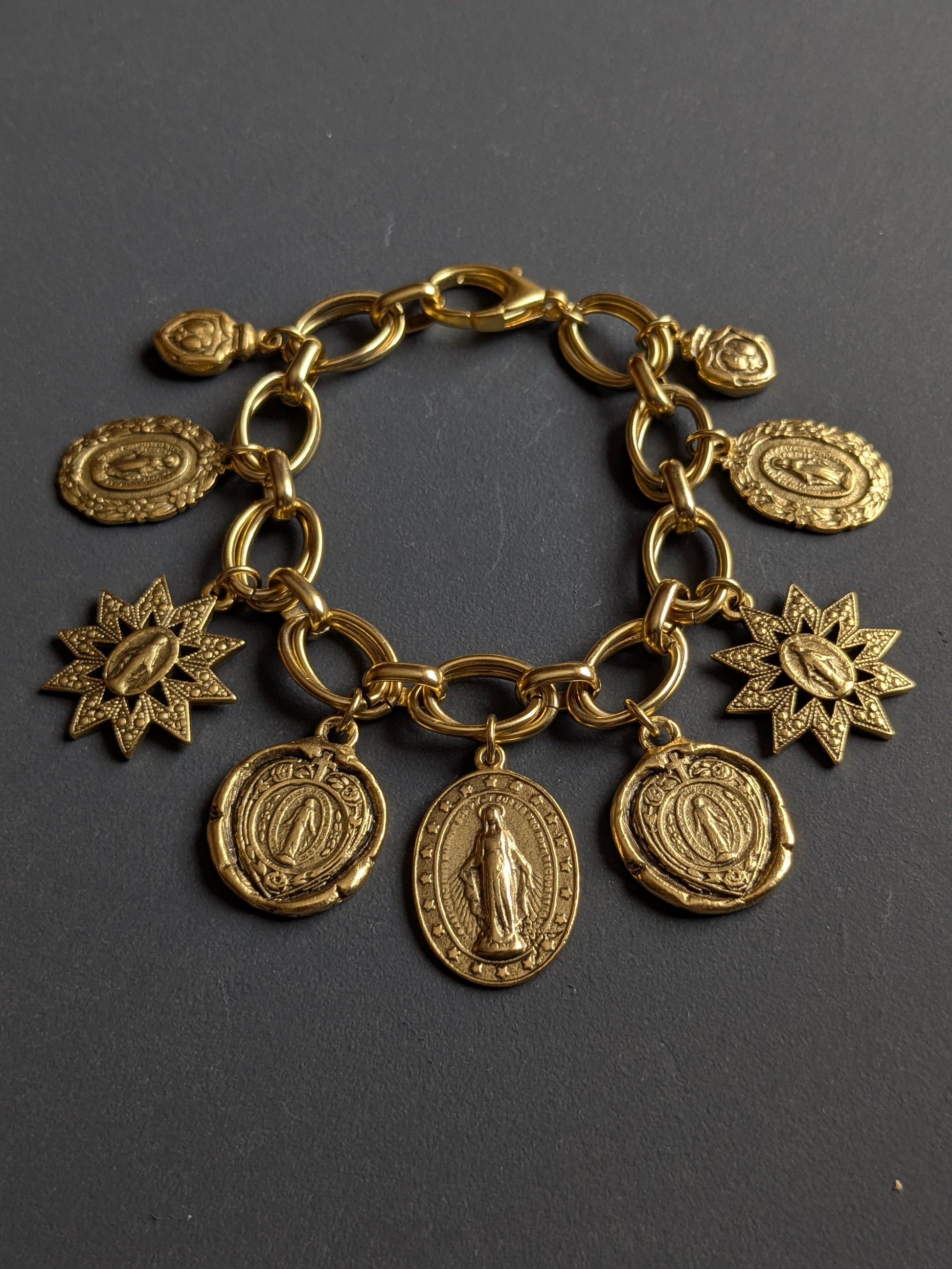 Détail des sept silhouettes de la Médaille Miraculeuse sur le bracelet Constellation, laiton plaqué or 12kt.