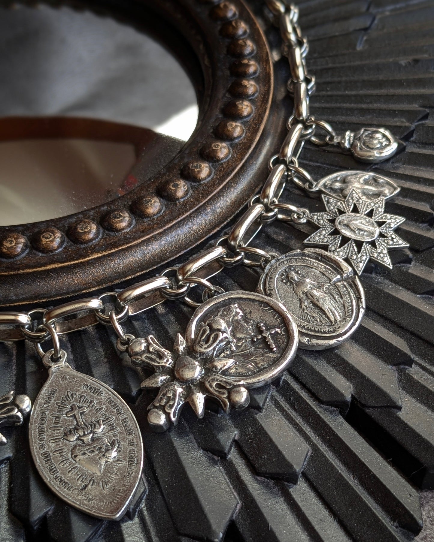 Zoom sur la médaille Jeanne d'Arc et le duo Cœur Sacré de Jésus / Vierge à l’Enfant sur le collier Manifesto de Mudra, symboles de conviction et de protection.