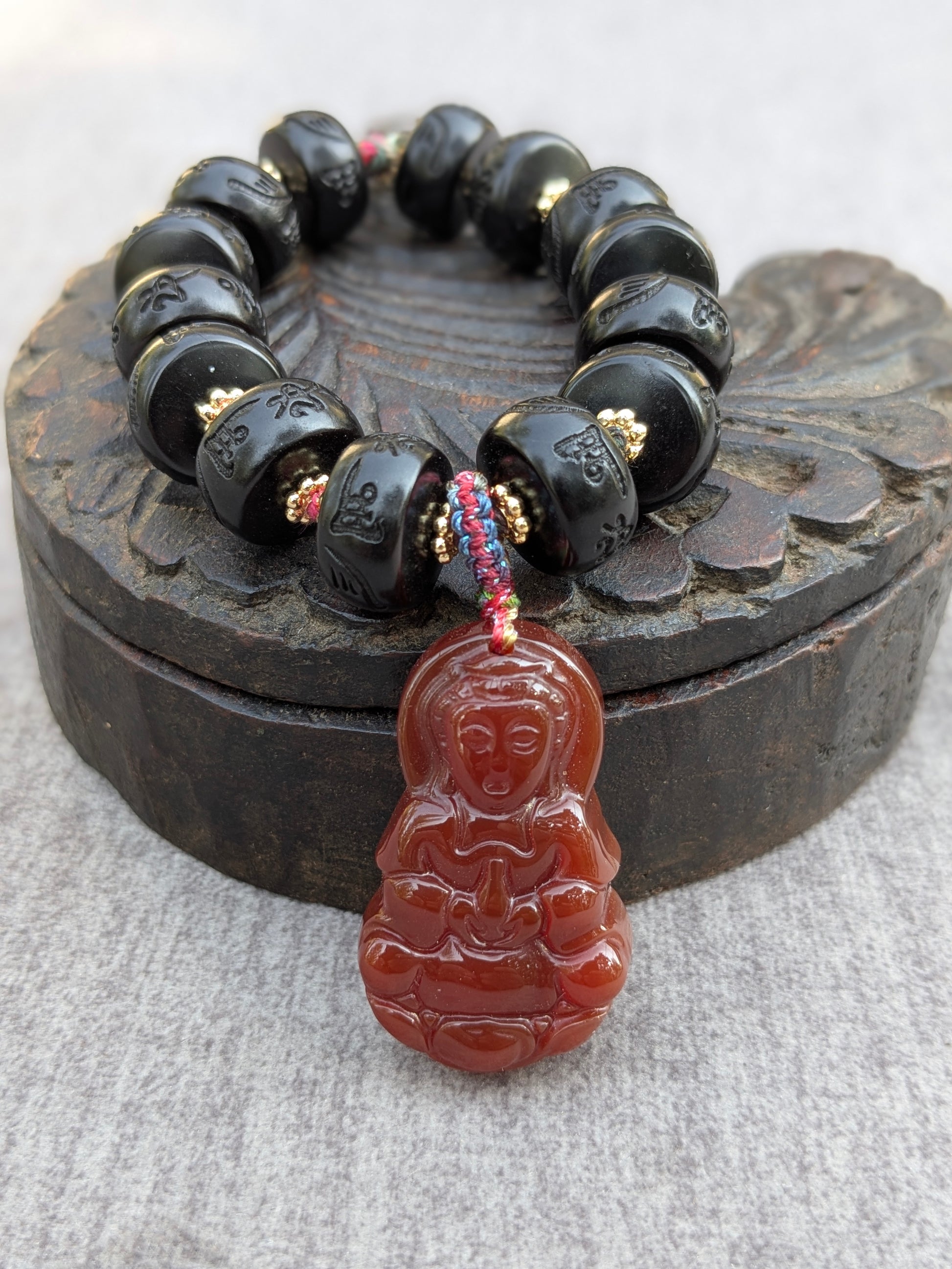Bracelet Dolma Mudra, Guanyin en agate rouge sur perles de bois de jujube noir gravées du mantra Om Mani Padme Hum