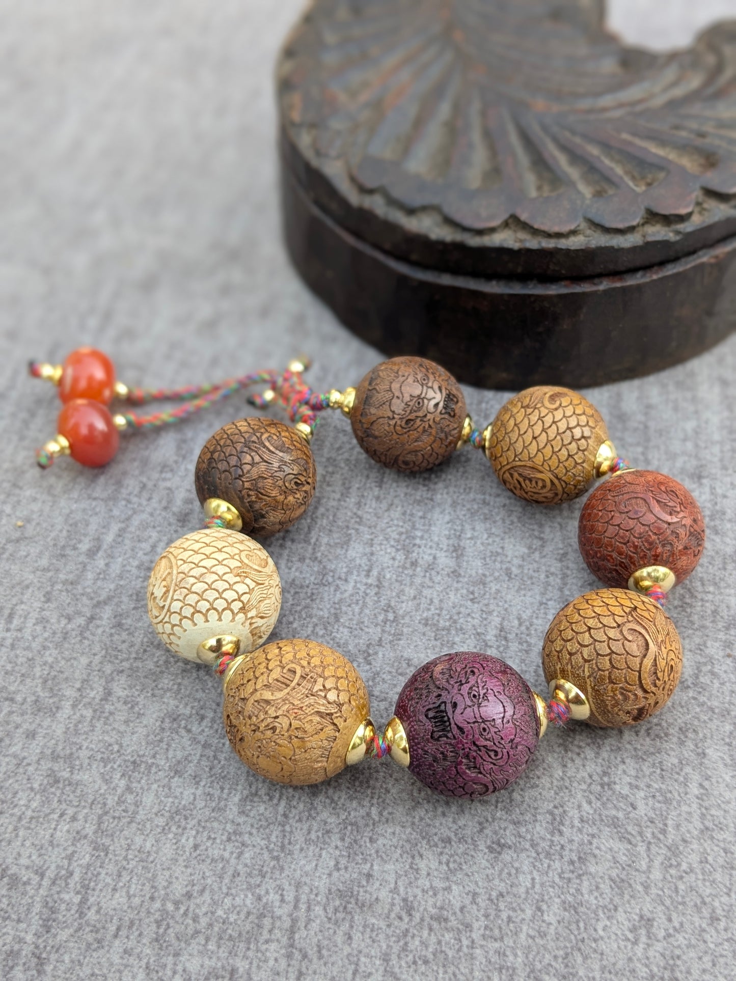 Bracelet Druk Mudra, vue d'ensemble des perles gravées de dragons avec pampilles en cornaline