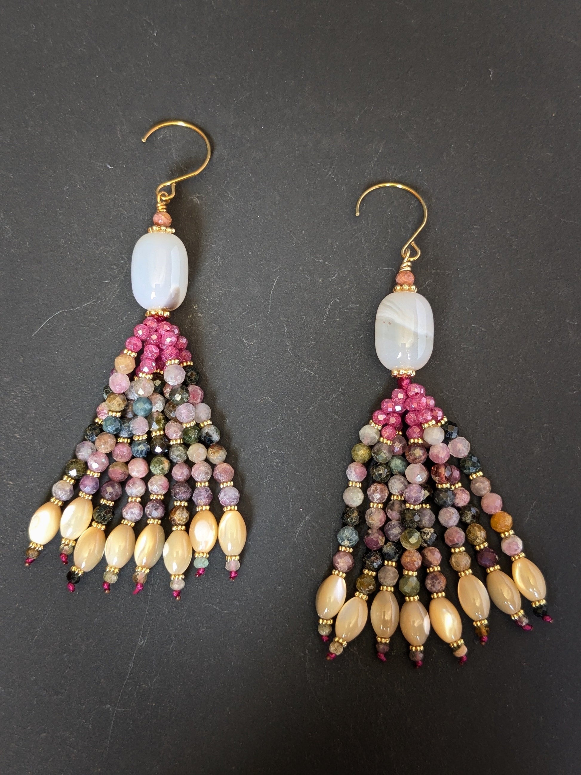 Paire de pendants d'oreilles Kiara Mudra posés sur un présentoir, calcédoine blanche et tourmaline multicolore