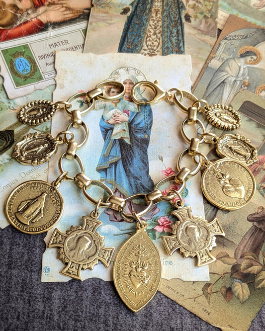 Bracelet Offrande par Mudra, une parure ex-voto solaire plaquée or 12 kt, composée de 9 médailles religieuses accumulées sur une chaîne robuste.
