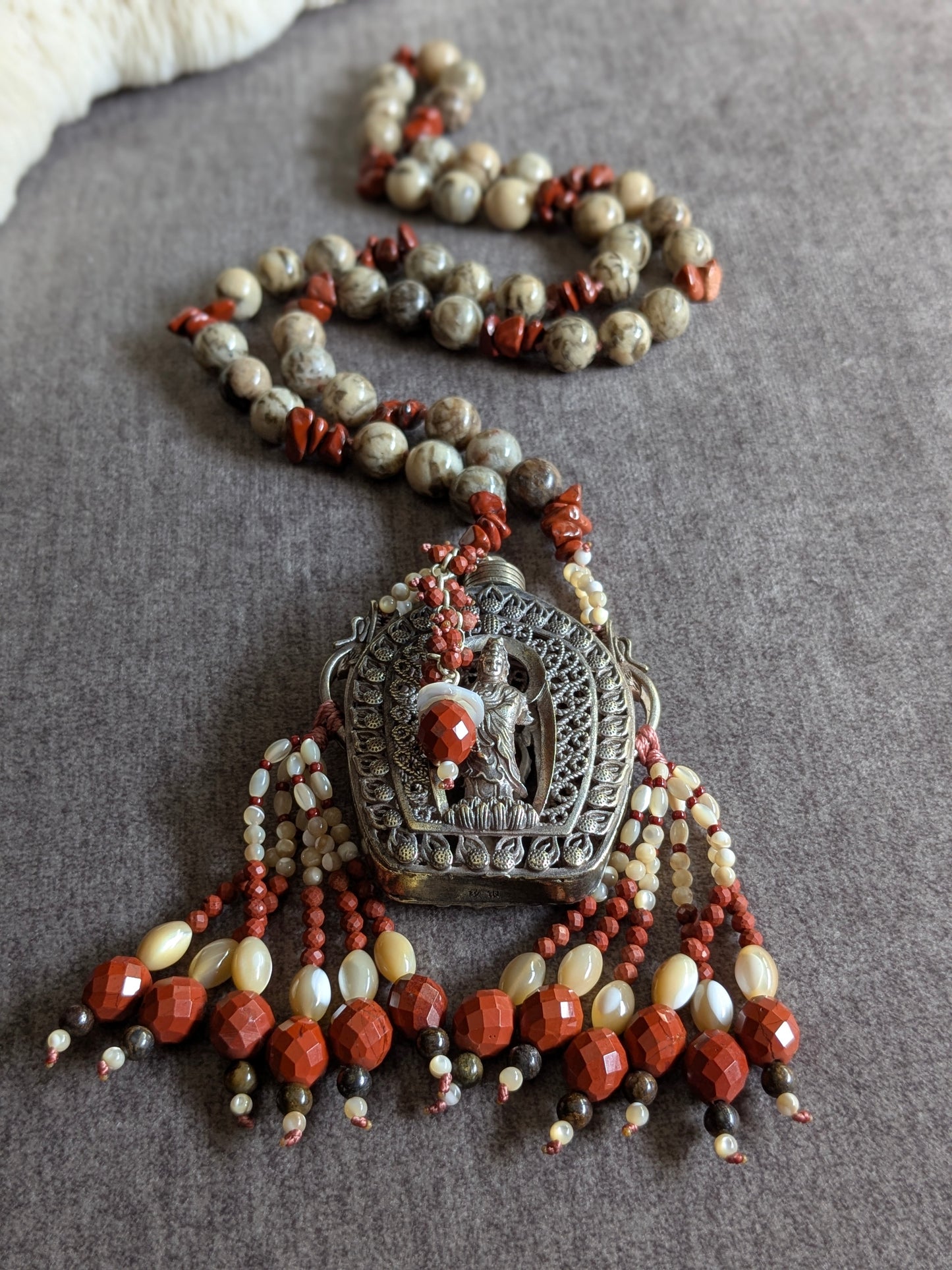 Vue rapprochée du pendentif Guanyin avec les deux tassels nacre et jaspe rouge
