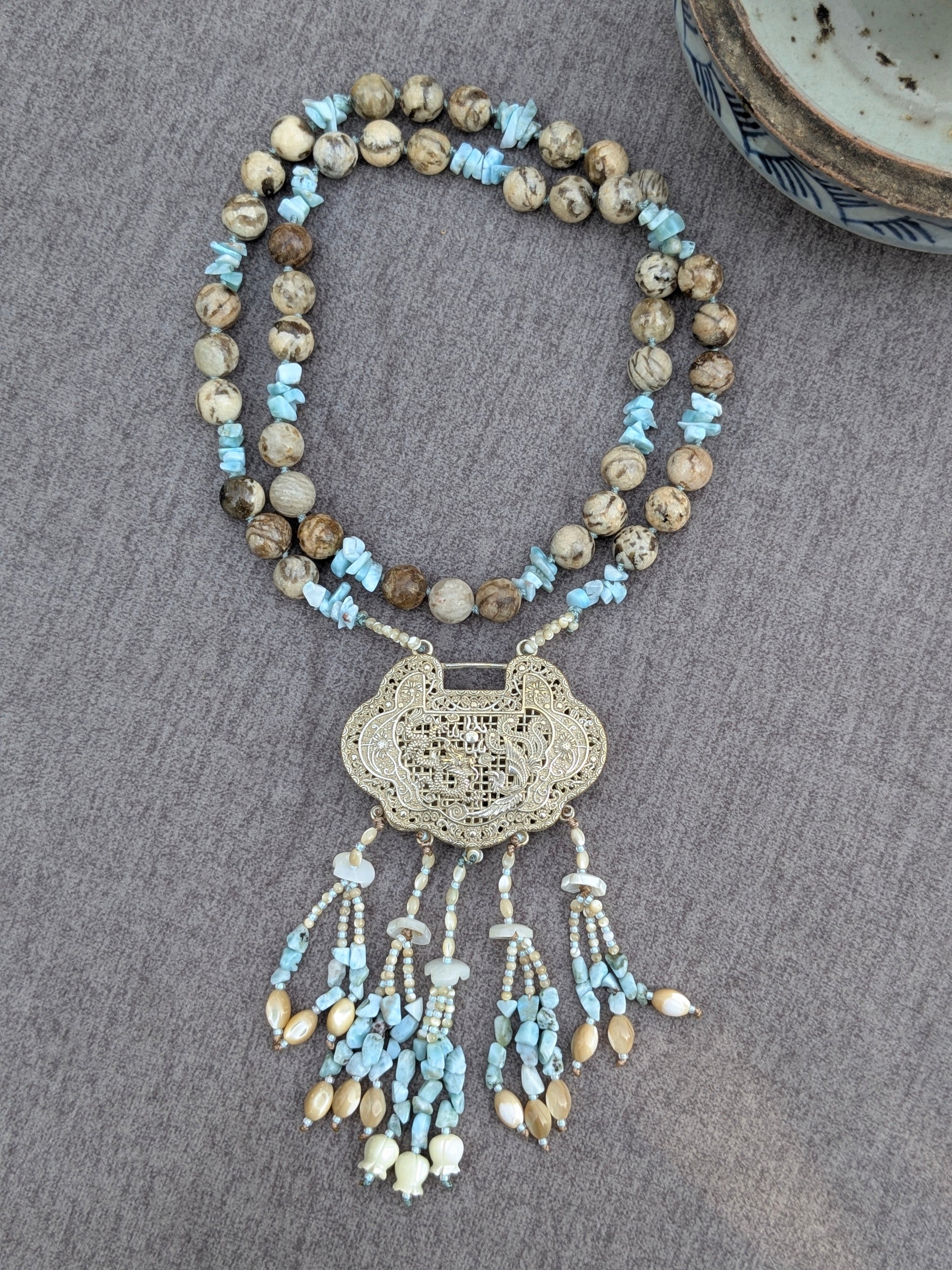 Collier He He noué, pendentif locket et tassel visibles, avec bol en porcelaine