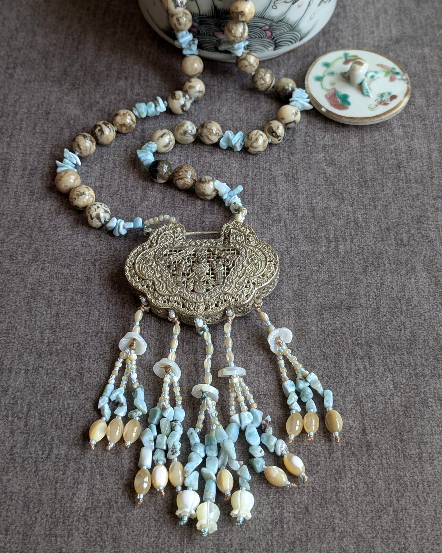 Collier He He noué avec locket réversible, vue d'ensemble avec théière en porcelaine