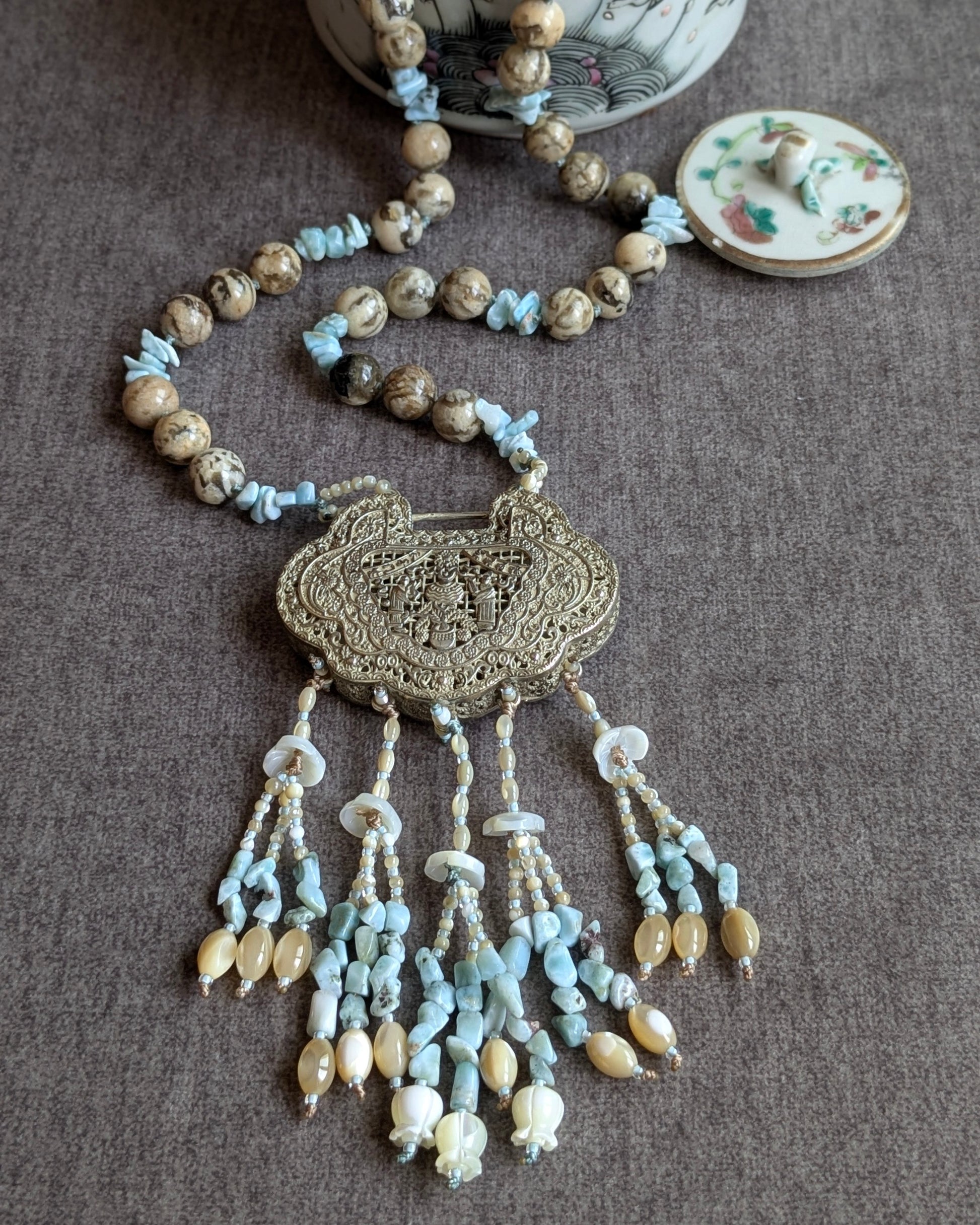 Collier He He noué avec locket réversible, vue d'ensemble avec théière en porcelaine