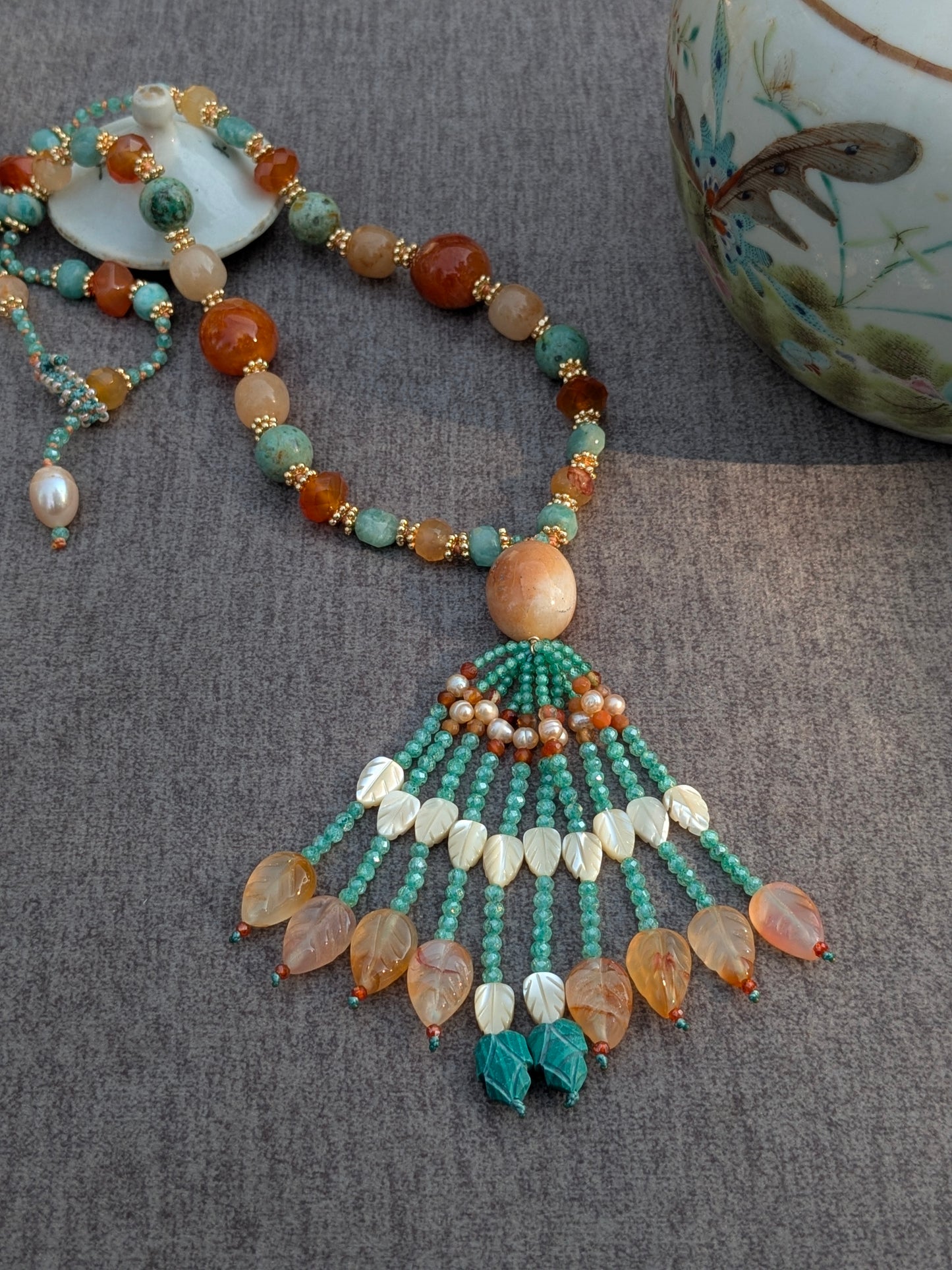 Collier Kesar noué, vue d'ensemble avec tassel sur une théière en porcelaine