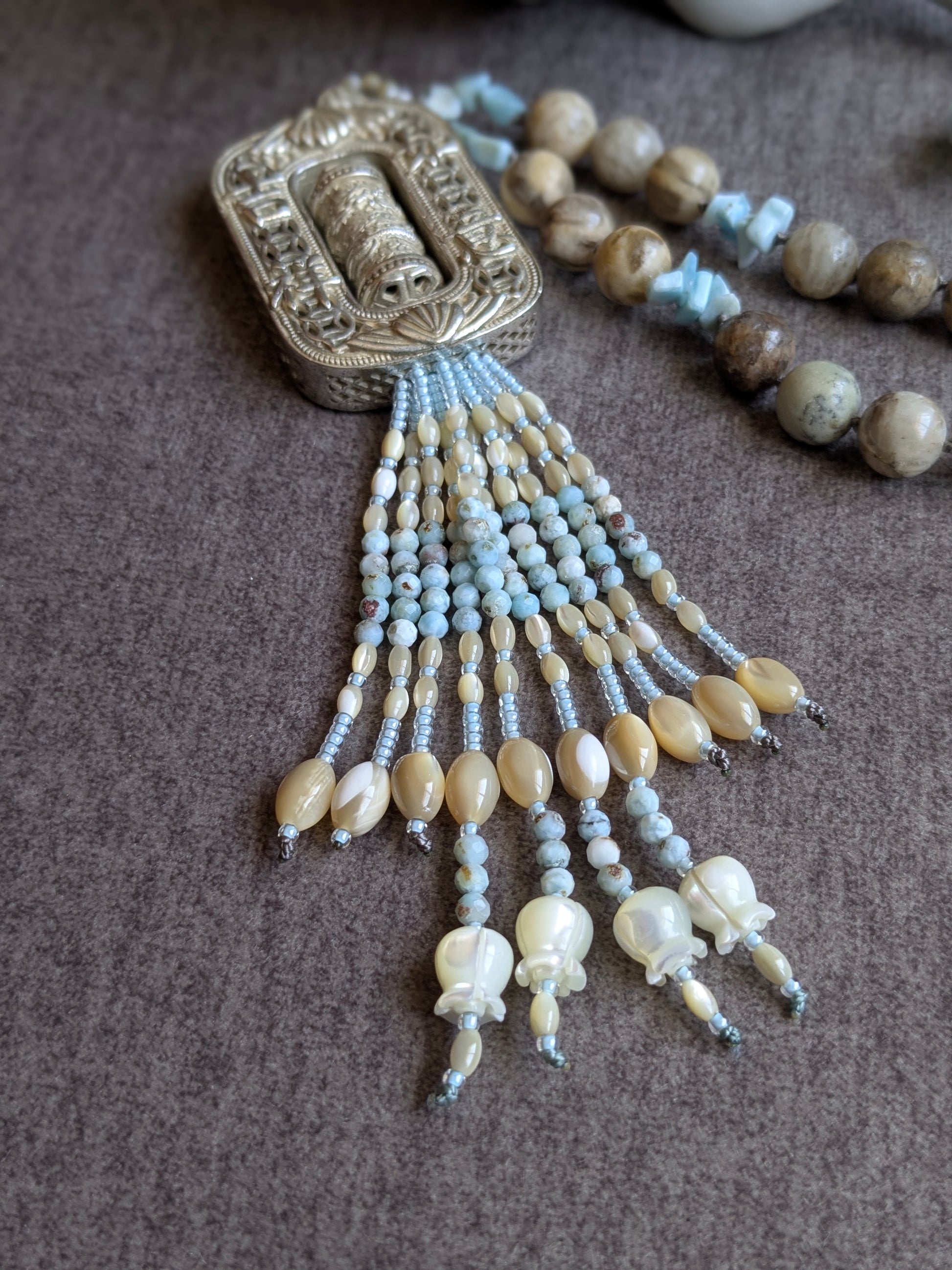 Détail du tassel signature Mani en rocailles miyuki, nacre et larimar