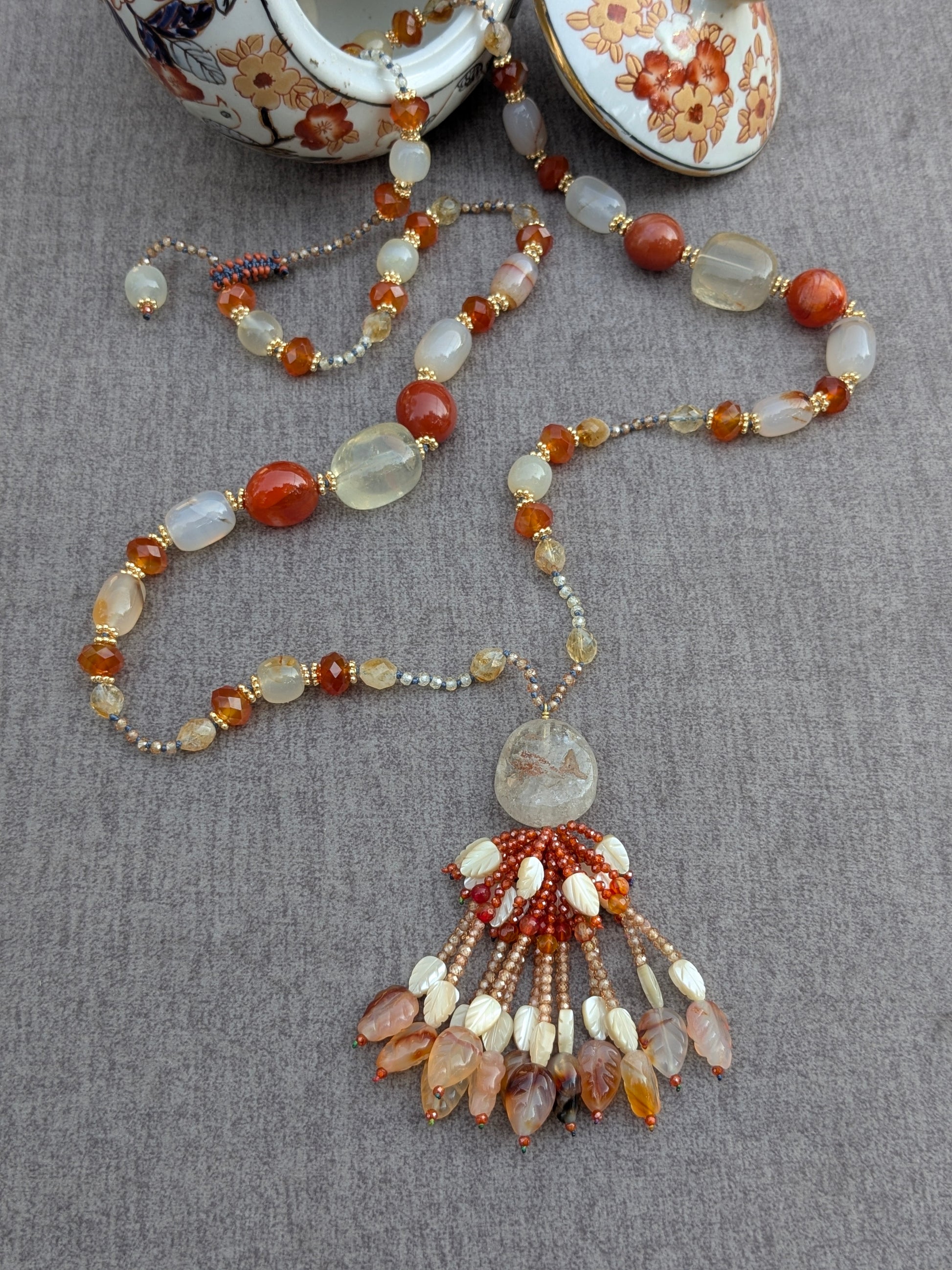 Collier Meera noué, vue d'ensemble avec le tassel et une théière en porcelaine