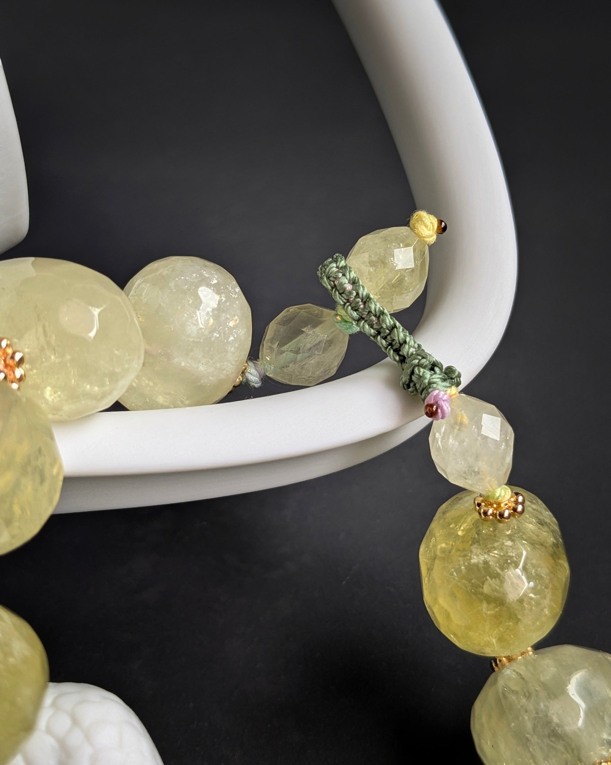 Gros plan du fermoir boutonnière en macramé vert d'eau tressé à la main