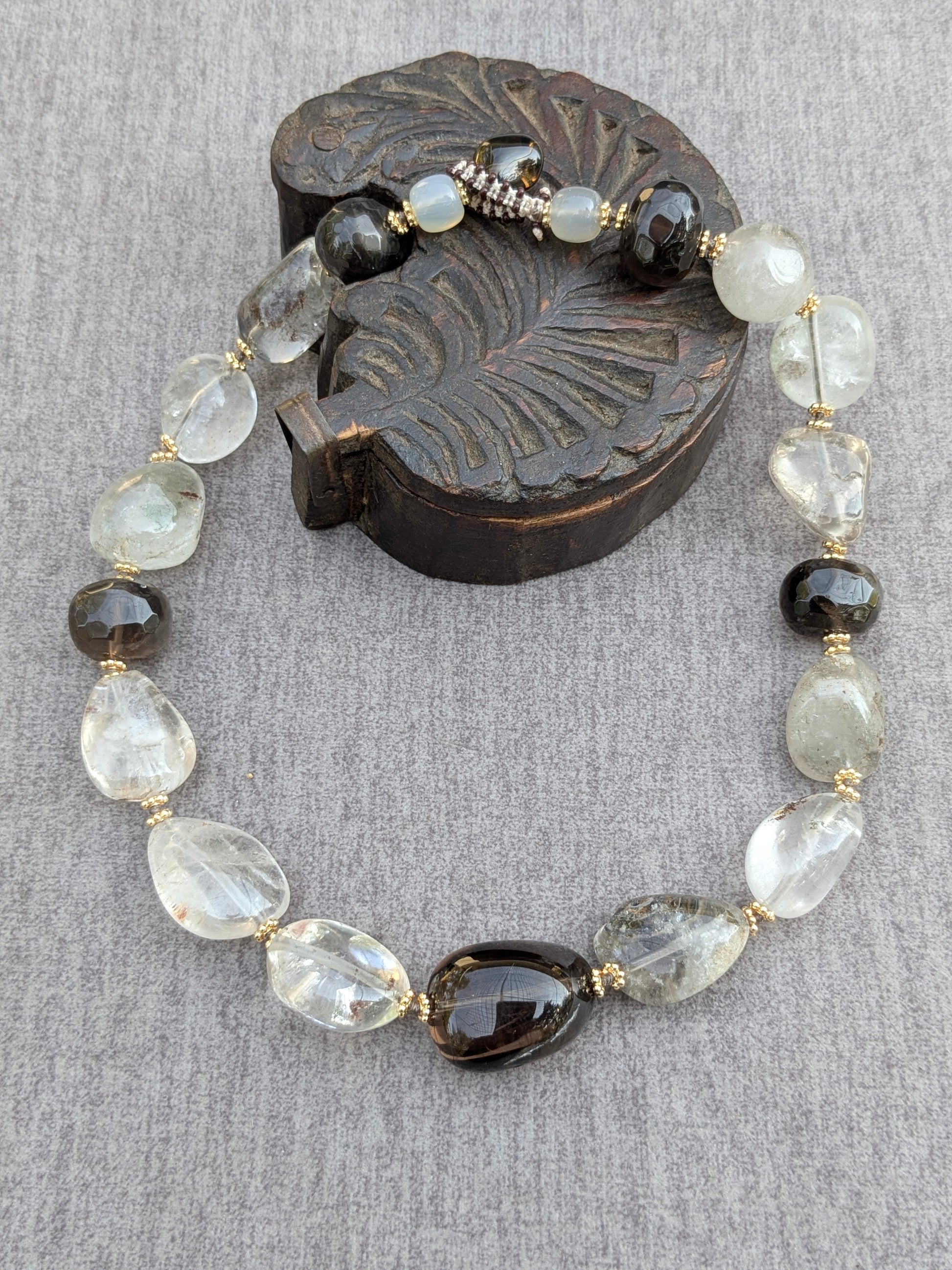 Ras de cou Shyama en quartz fantôme et quartz fumé, vue d'ensemble sur socle en bois