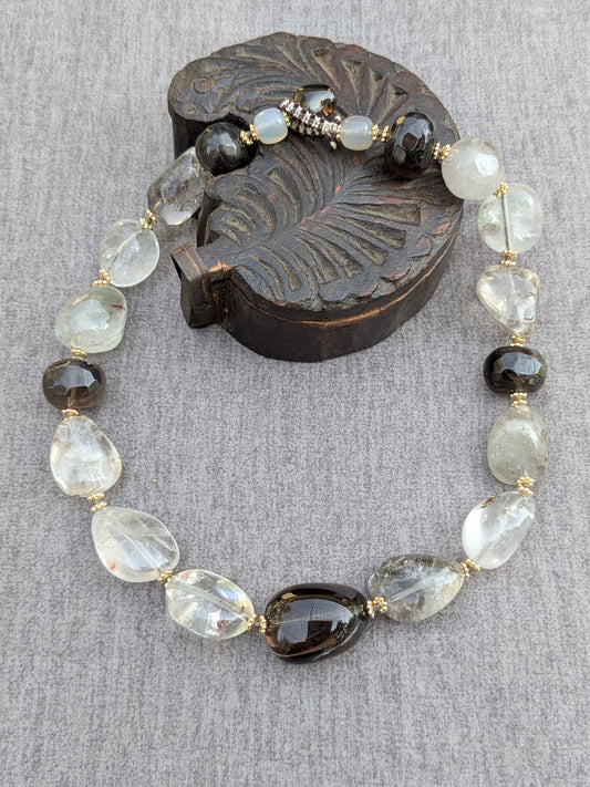 Ras de cou Shyama en quartz fantôme et quartz fumé, vue d'ensemble sur socle en bois