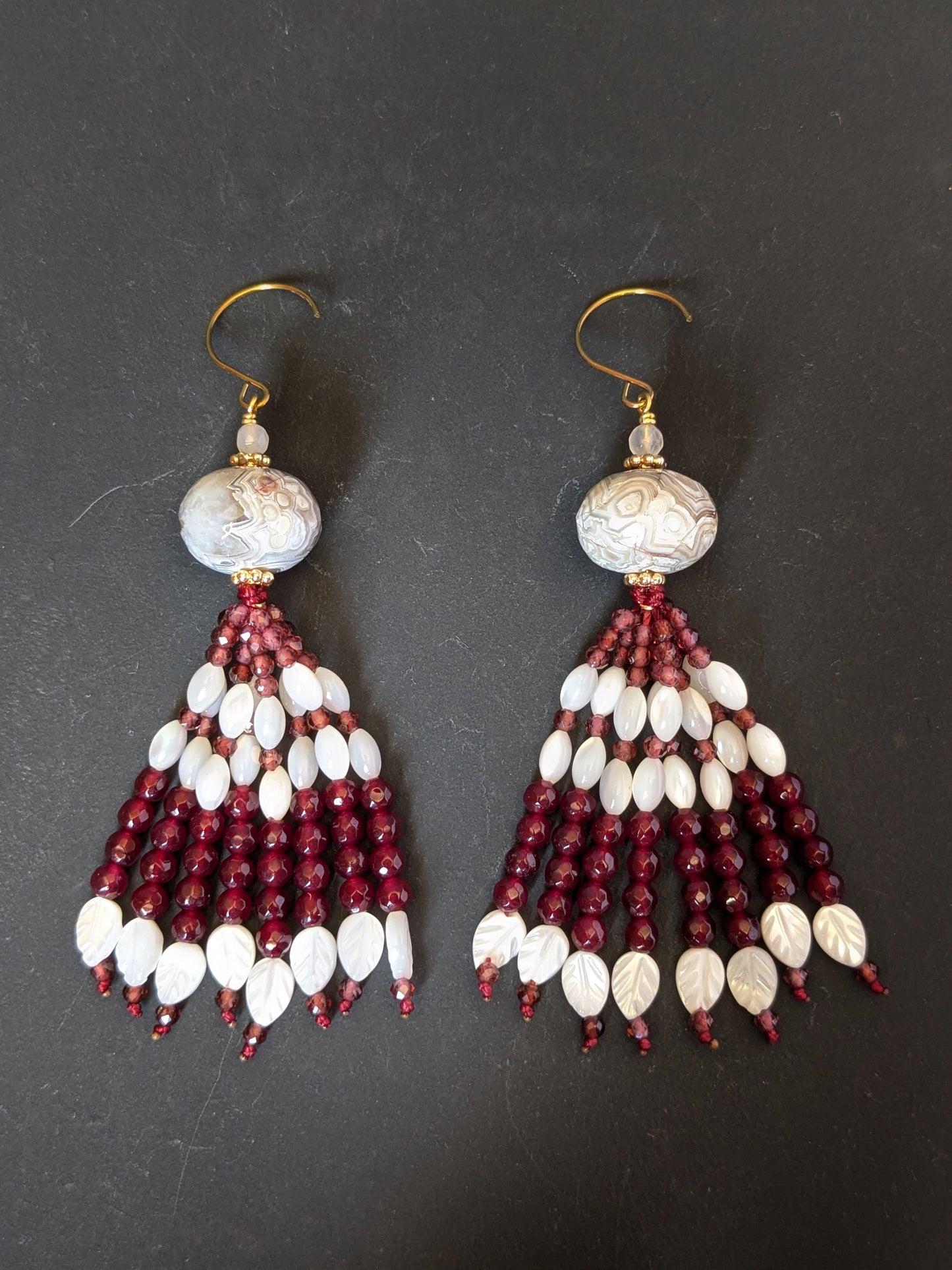 Paire de pendants d'oreilles Vani posée à plat, agate teintée cerise et feuilles sculptées en nacre