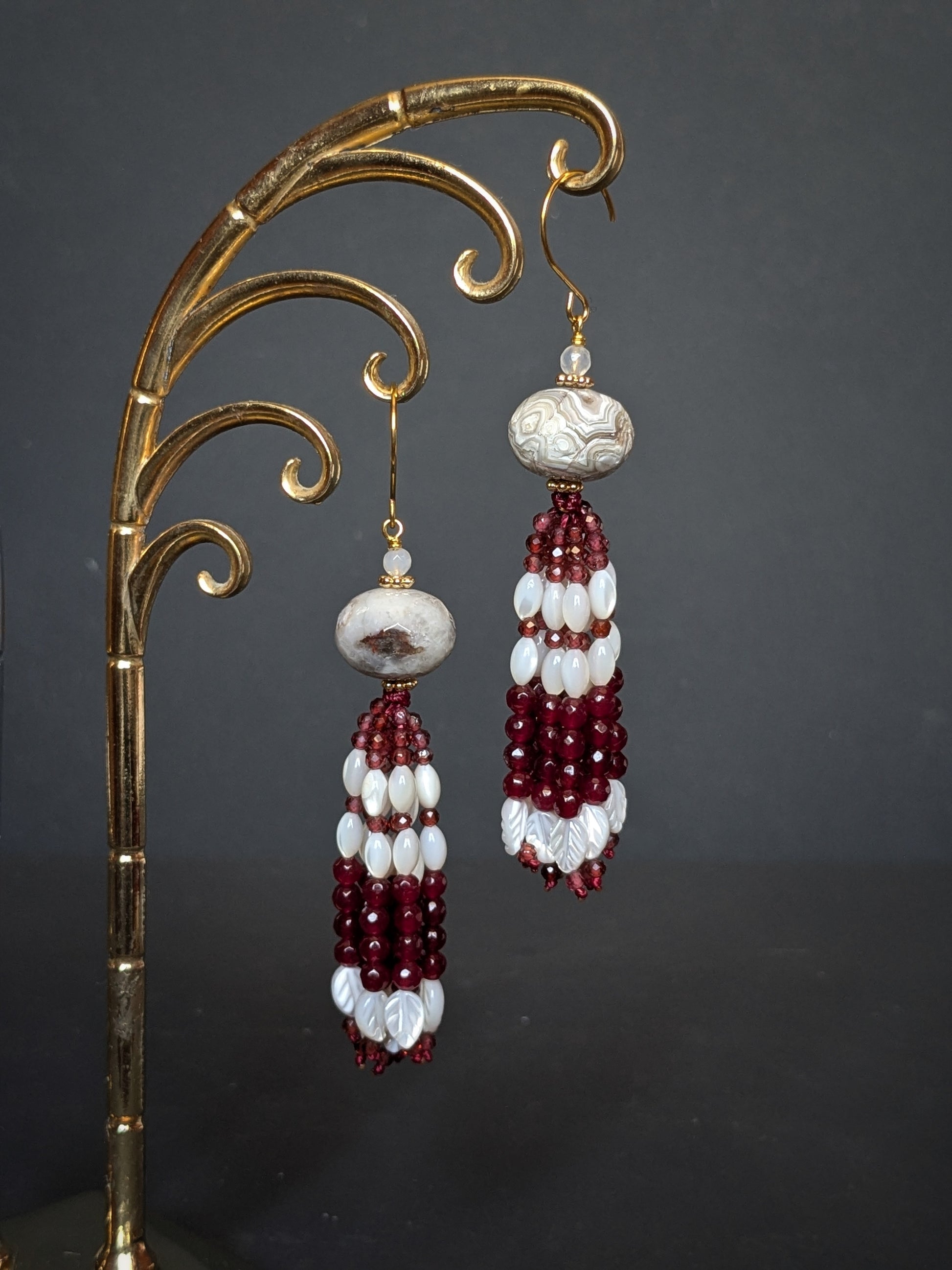 Pendants d'oreilles Vani posés sur un présentoir, agate mexicaine et tassel de grenat et nacre blanche